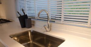 Modern kitchen with white blinds over the sink