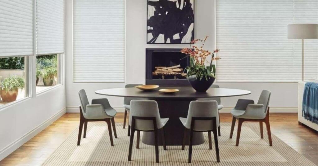 Modern dining room with elegant decor and window shades.